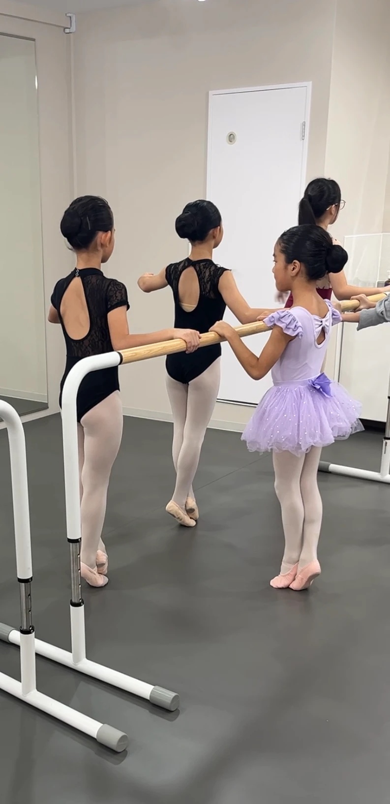 バーにつかまってレッスンをする子どもたち